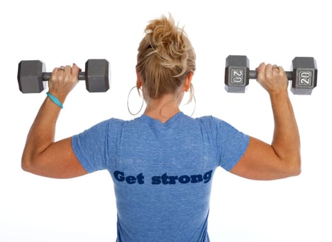 Rear view of woman lifting dumbbells against white background.