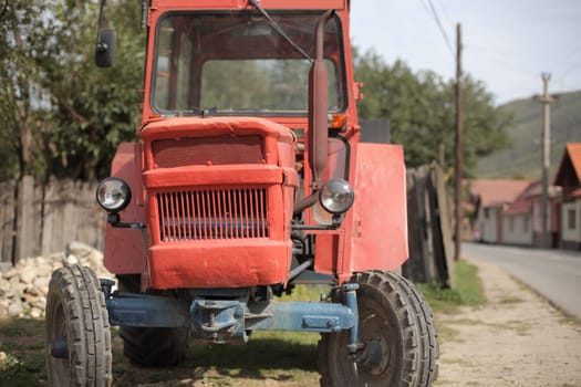 Old red funny traktor in the village