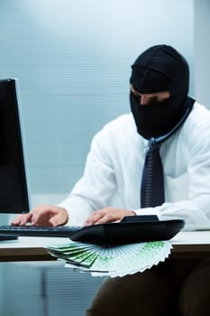 A desk clerk wearing a balaclava while doing some swindle about money (focus on the money)