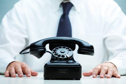 black telephone on focus with a business waiting for a call on the background