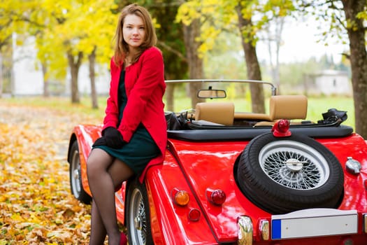 Woman in red and car at autumn park