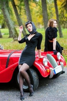 women in black relay on red car front