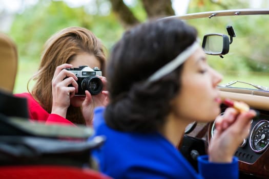 One woman take photo of other at car