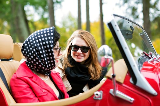 Pretty women at retro car take interesting dialog