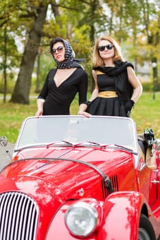 Pretty women with dark glasses with retro car