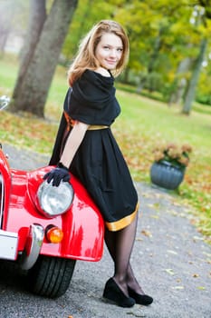 Happy woman in black and retro car headlight
