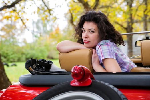 Pretty woman relay at retro car seat back