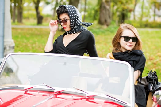 Pretty women with dark glasses behind car windscreen