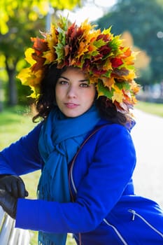 Young woman at sunny day with leaf wreath