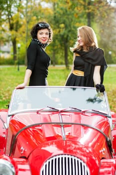 Pretty women in black dress at autumn park
