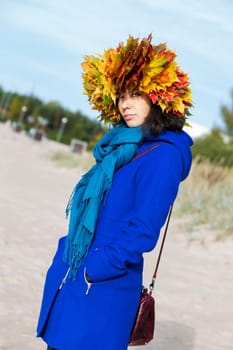 Woman in coat with maple leaves on head