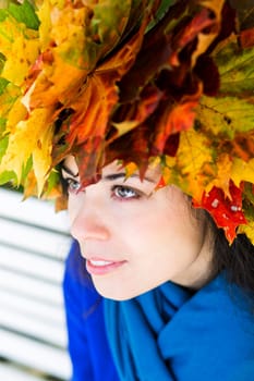 Woman with maple leaves on head is dreaming