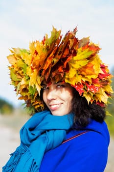 Smiling woman with yellow maple leaves on head