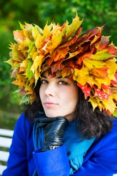 Thoughtful young woman with maple leaves on head