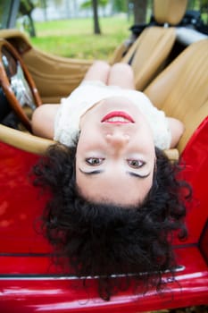 Woman raised her head over retro car door