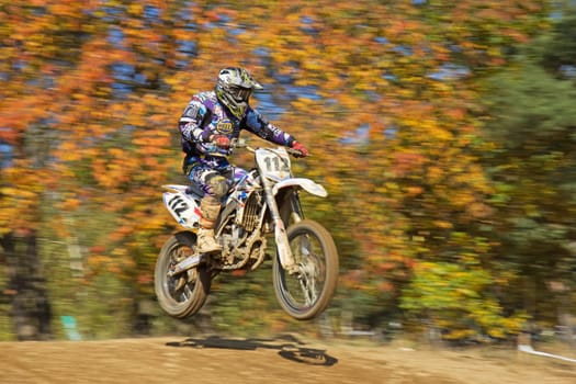 ZABREH, CZECH REPUBLIC - OCT 19. Motocross racer in blue and white is jumping at Motocross Zabreh Cup on October 19, 2013 in Zabreh, Czech Republic (Central Europe)