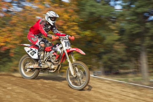 ZABREH, CZECH REPUBLIC - OCT 19.Closeup dynamic shot of motocross rider in red, which is riding at Motocross Zabreh Cup on October 19, 2013 in Zabreh, Czech Republic (Central Europe)