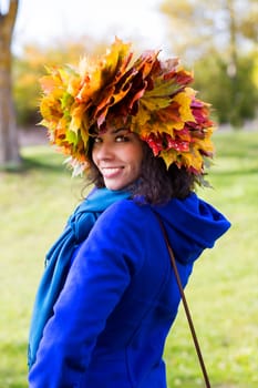 Woman with maple leaves on head at park