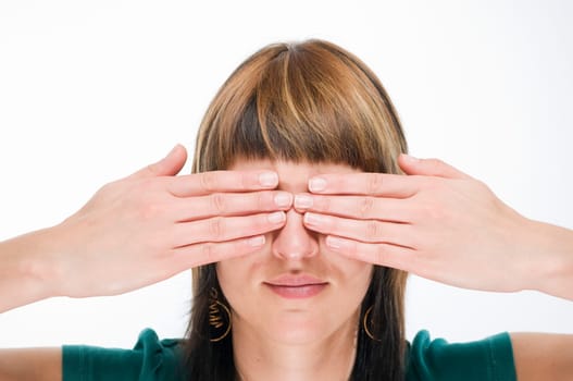 Head-and-shoulder view of a young woman looking into the camera and covering her eyes  Gesture