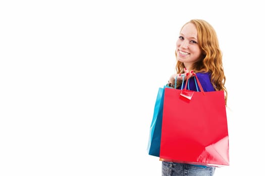 Happy young woman with shopping bags turns around against a white background