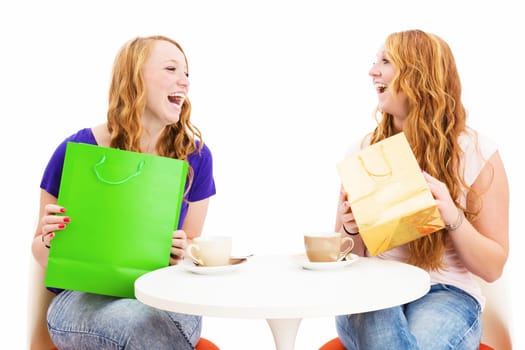 Cheerful women having coffee with shopping bags against a white background