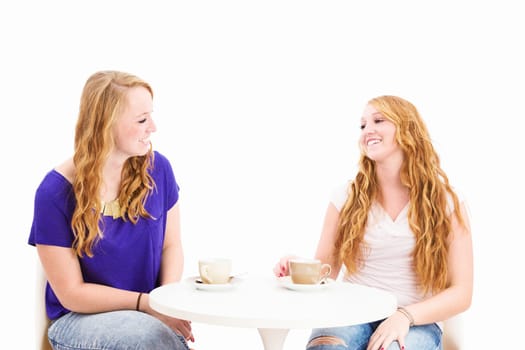 Two happy women having coffee in front of a white background