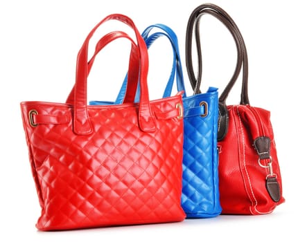 Three leather handbags isolated on white background