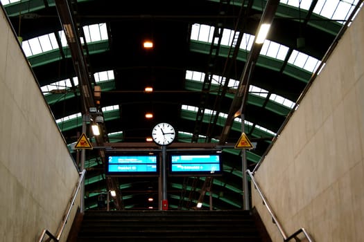 Berlin,Germany – January 02,2013: The staircase of a platform in Berlin's Ostbahnhof with a clock and train displays on January 02,2013 in Berlin.