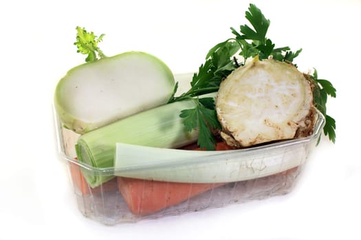 various soup vegetables against a white background