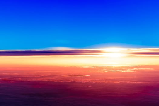 sunset with a height of 10 000 km. Dramatic sunset. View of sunset above clouds from airplane window