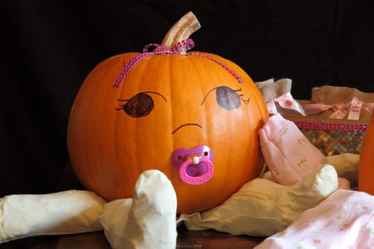 A cute and round pumpkin dressed up like a baby