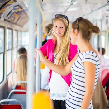 Pretty, young woman on a streetcar/tramway, during her commute to work/school (color toned image  shallow DOF)