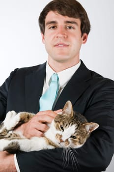 Upper body portrait of a man in a black suit with a wiggling cat in his arms smiling into the camera
