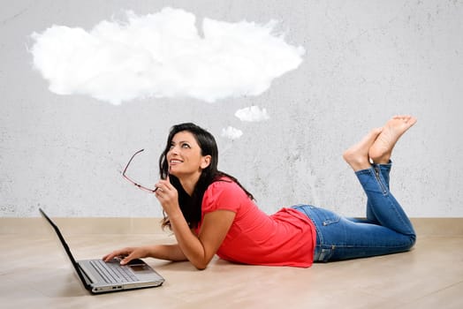 Beautiful Caucasian woman smiles thinking in front of his laptop. Concept of the Internet. Woman lying full length isolated on white background