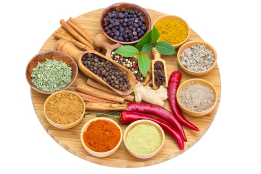 Variety of spices on wooden board, isolated on white