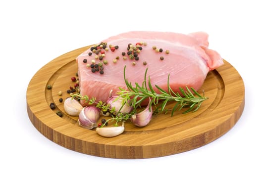 turkey meat on wooden board with various herbs and spices
