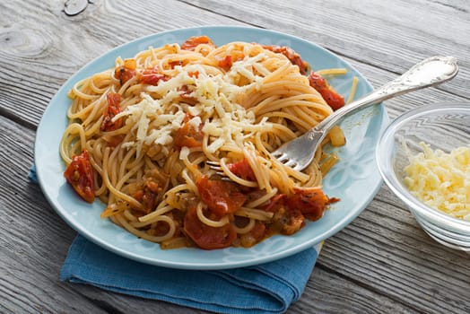 Spaghetti with tomato sauce and cheese close up