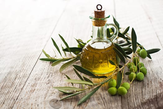 Olive oil and olive branch on the wooden table