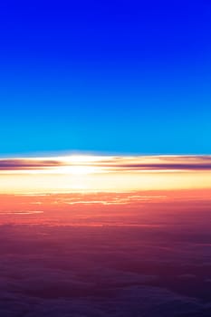 sunset with a height of 10 000 km. Dramatic sunset. View of sunset above clouds from airplane window