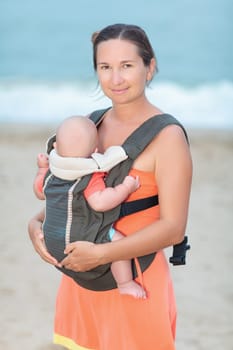 Young mother with baby on the beach