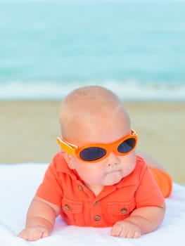 Cute baby laying on the sunbed at the beach