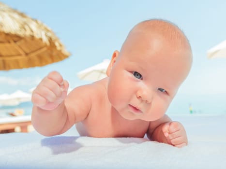 Cute baby laying on the sunbed at the beach