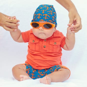 Cute baby sitting on the sunbed at the beach