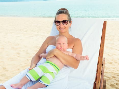 Baby and mom are relaxing on sunbed