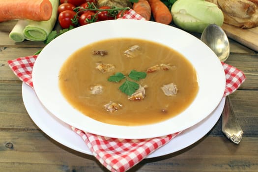 white plate with duck soup,cream and parsley