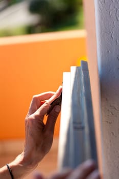 Hands of a woman with sandpaper doing DIY work on wooden fixtures