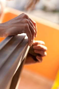 Hands of a woman with sandpaper doing DIY work on wooden fixtures