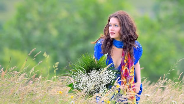 girl with bouquet of white flowers in green field