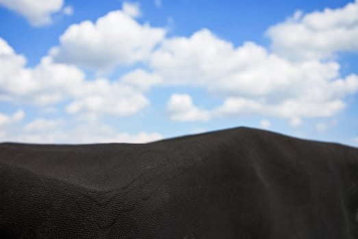 Black tarpaulin with sky and clouds