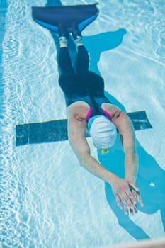 Female freediver with monofin swimming underwater in swimming pool